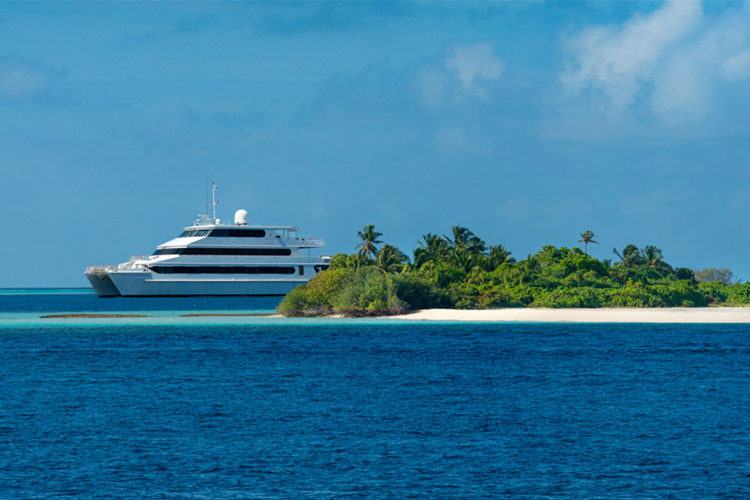 The Four Seasons Explorer Boat sitting off a deserted islands