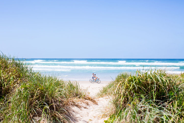 couple riding along the beach infront of Halcyon House