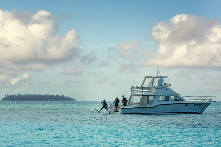 Four Seasons Kuda Haruu, Maldives scuba divers jumping into water from boat